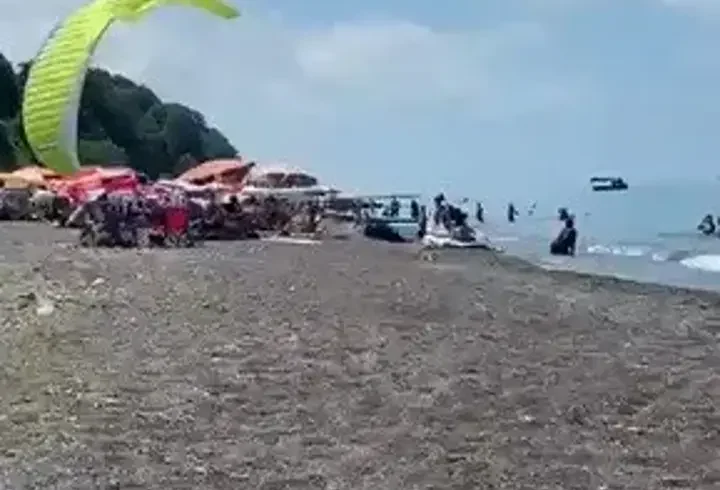 Sahilde motorlu yamaç paraşütüyle havalanırken tatilcilerin arasına daldı