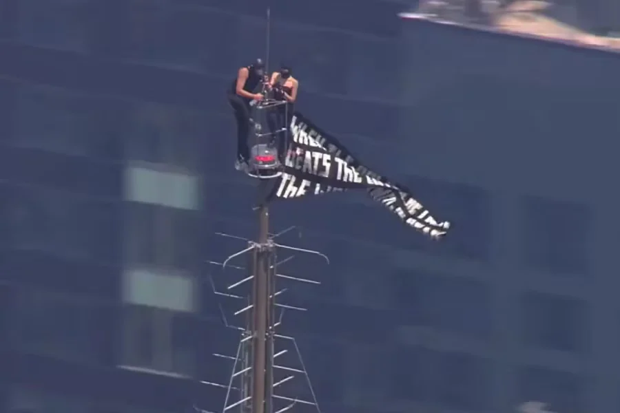Dos personas suben a la cima del Empire State Building y despliegan una pancarta a favor de la paz
